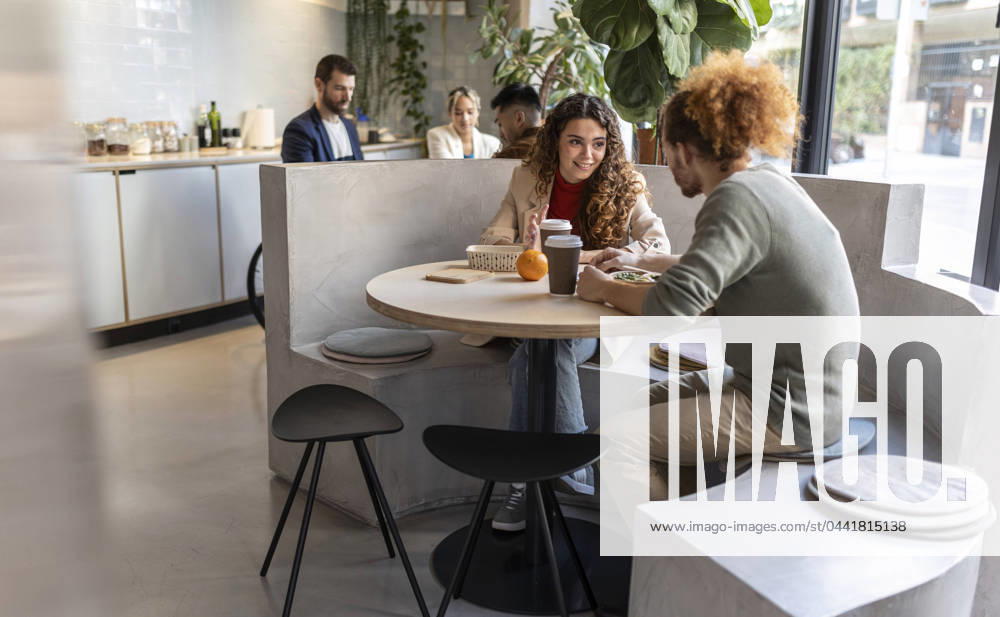 Business colleagues having lunch sitting on seat at office cafe model released, Symbolfoto property released, JCCMF11306