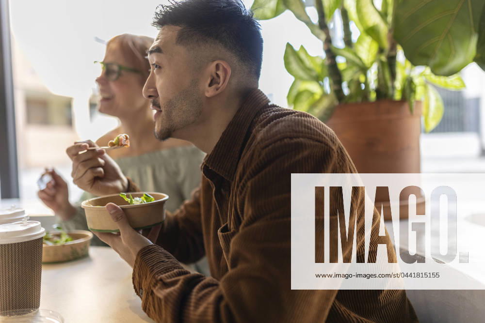 Businessman eating lunch with colleague at office model released, Symbolfoto property released, JCCMF11309