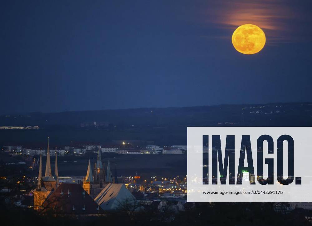FULL MOON OVER ERFURT 25 03 2024 Erfurt The reddish, yellow shining full moon rises in the evening on the horizon over the state capital Erfurt in the foreground the cathedral and Severi can be seen Germany Thuringia Erfurt Copyright SaschaxFromm