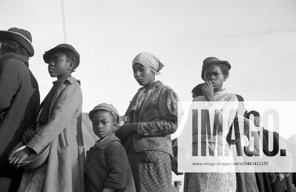 FLOOD REFUGEES, 1937. People waiting in a food line at a flood refugee camp in Forrest City, Arkansas. Photograph by Walker Evans, February 1937.
