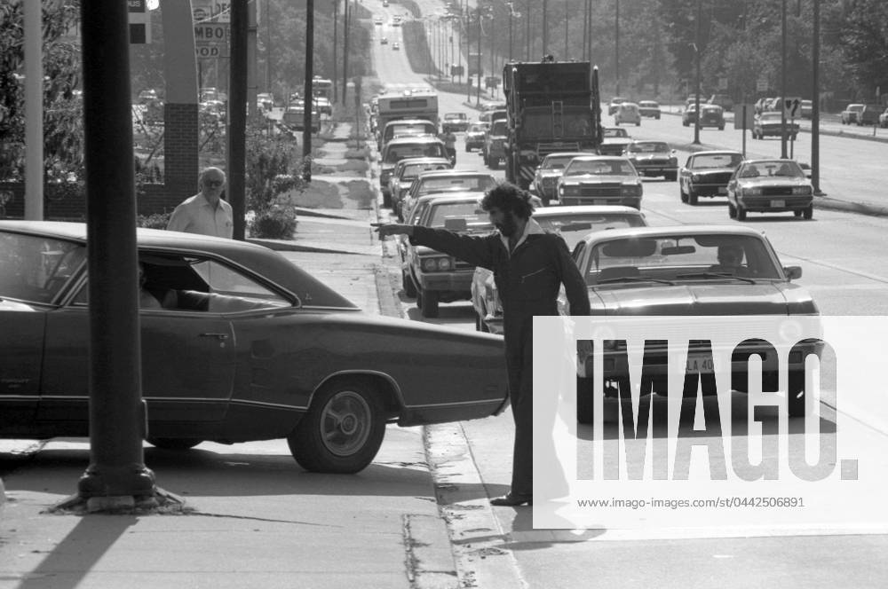 IMAGO History, Ölpreiskrise 1973 OIL CRISIS, 1979. A gas station attendant directing cars at a service station during the oil crisis. Photographed by Thomas J. O Halloran