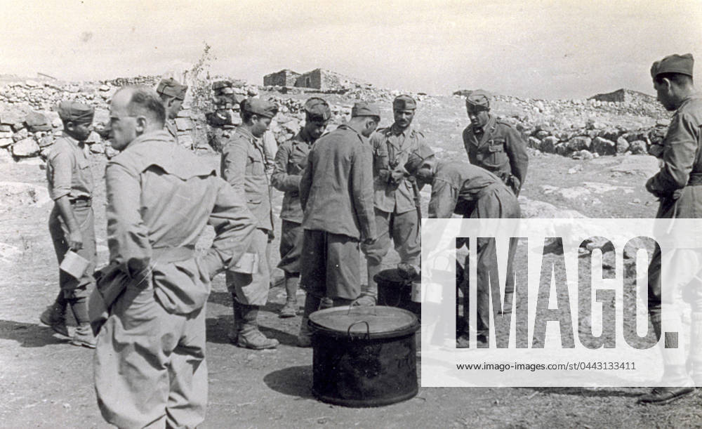 A few Italian soldiers photographed during the distribution of mess. In the foreground a large pot with cover set on the ground can be seen. A soldier is filling the mess-tins to be distributed to the waiting soldiers from another pot, 07 1938 (b w photo) 1250078 A few Italian soldiers photographed during the distribution of mess. In the foreground a large pot with cover set on the ground can be seen. A soldier is filling the mess-tins to be distributed to the waiting soldiers from another pot, 07 1938 (b w photo) by Unknown photographer, (20th century); (add.info.: Unidentified Author Spain); Fratelli Alinari Museum Collections, Florence, Italy.