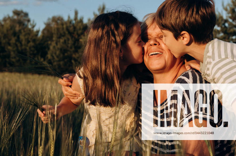 IMAGO Creative, Jahreszeit Sommer, Sommerferien Boy and girl kiss grandma at sunset Moscow, Moscow, Russia CR_ITUP240402-1366199-01 ,model released, Symbolfoto