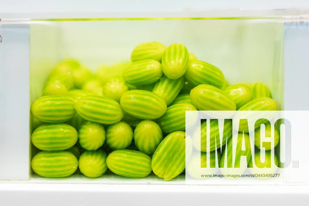 Bright green cucamelons neatly packed in a transparent glass container, viewed from the side against a white background Model Released HodeiUnzueta_ID20289_600326_005