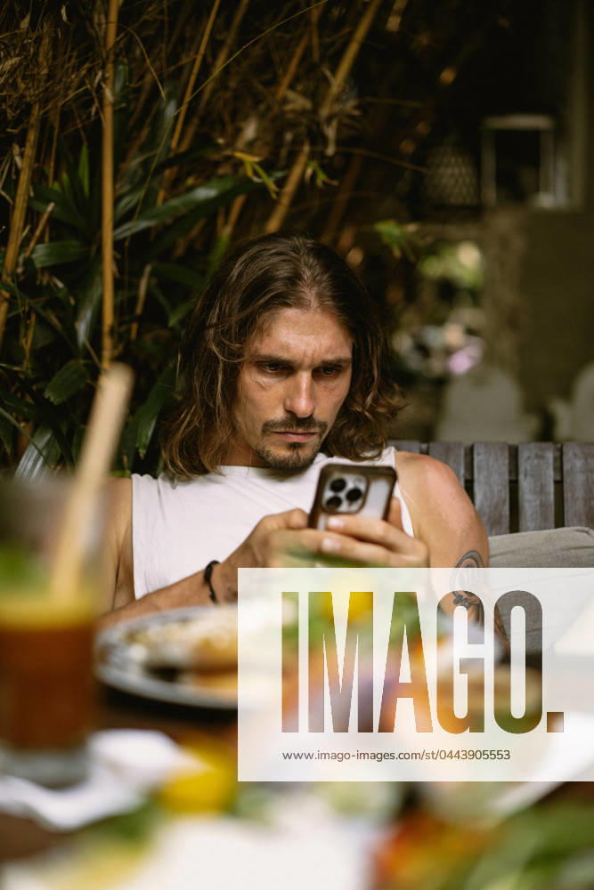 Portrait of a man in a restaurant using the phone during lunch. Paris, Île-de-France, France R_YUKI2404044D-1373724-01 ,model released, Symbolfoto