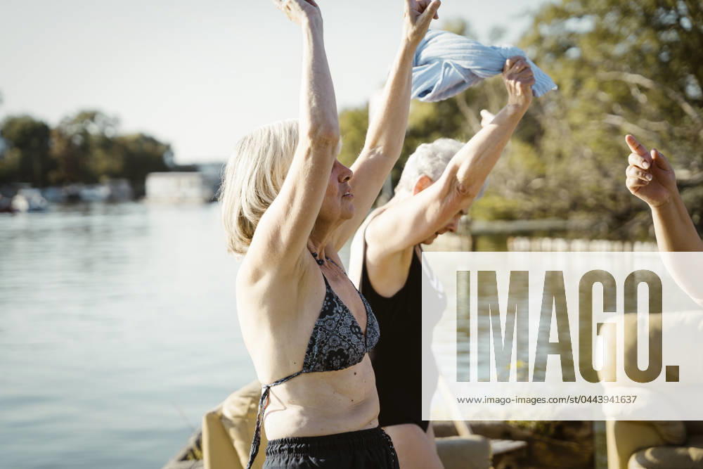Carefree senior female friends dancing during vacation on houseboat Germany, Berlin, model released, property released