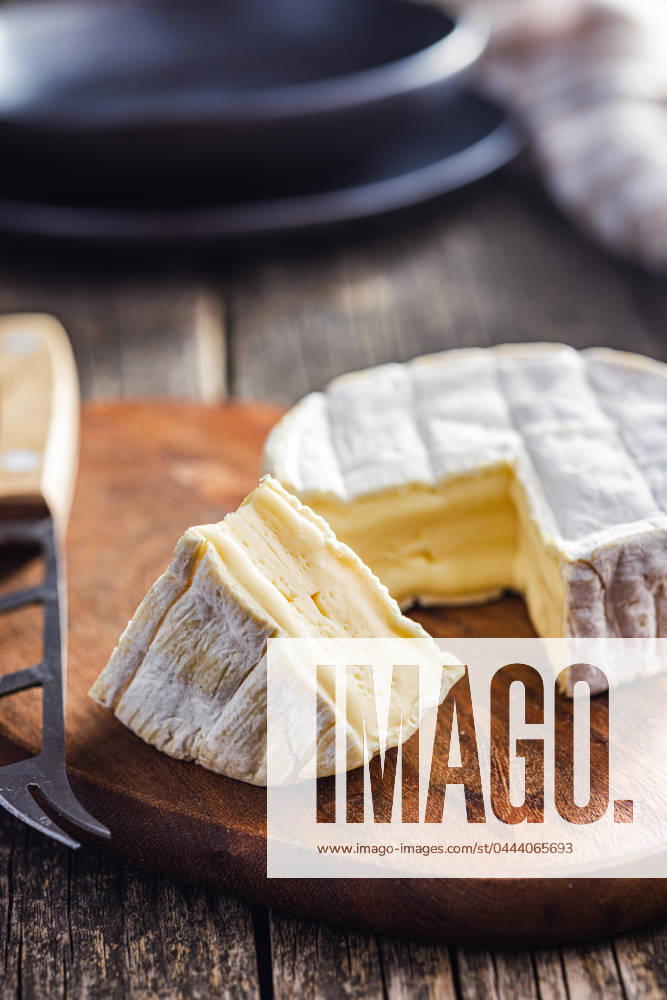 Brie type cheese with white mold. French camembert cheese on cutting board. Brie type cheese with white mold. French camembert cheese on the cutting board.