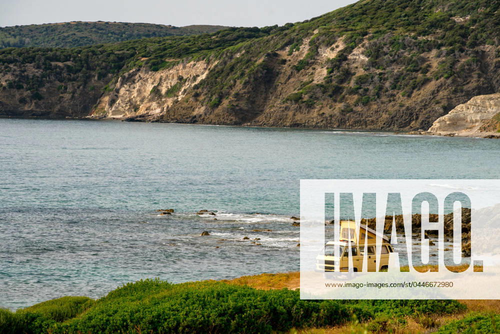 Old retro yellow camper van near the sea on a wild landscape Magazzini, Sardegna, Italy CR_UGOUSD240415-1391163-01