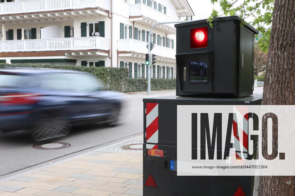 Bavaria, Germany 19 April 2024 A speed camera, red light monitoring, speed monitoring, speed camera trailer on a road with passing cars, speed camera marathon, fine, car, too fast, speeding, speed limit as symbolic image, trigger, red light, flashed, speed measurement