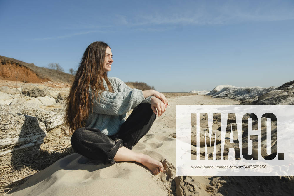 Smiling woman sitting on rock at sunny day model released, Symbolfoto, KVBF00068