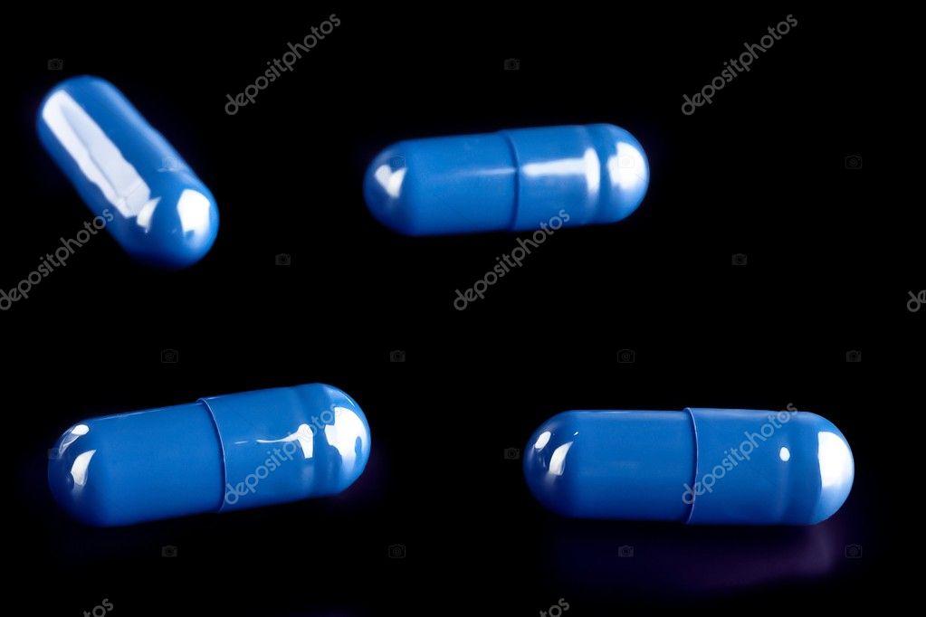 Detail of blue pills for medical care on black background