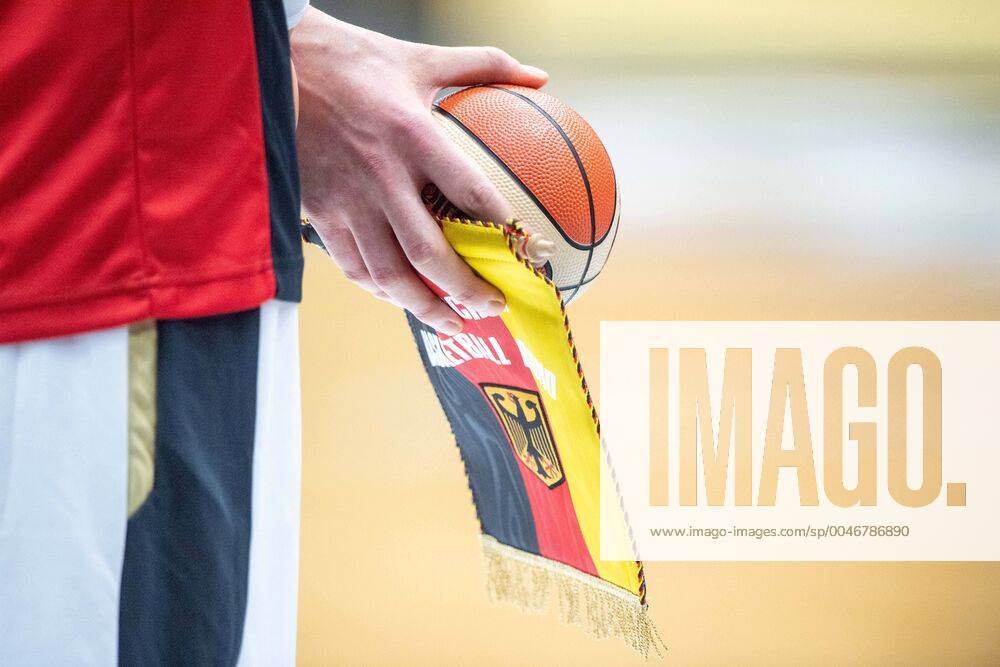 A German player holds the pennant and a small basketball in his hands, Feature, general, edge motif, Basketball EM Qualification, Group G, Germany GER France FRA 83 69, on 21 02 2020 in Vechta Germany Â