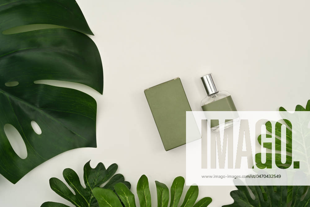 Mockup of fragrance perfume bottle with tropical leaves on white background Mockup of fragrance perfume bottle with tropical leaves on white background.