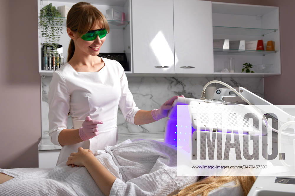 Young woman having photodynamic therapy in beauty salon Led phototherapy for the face. LED lamp for photodynamic therapy. Face care