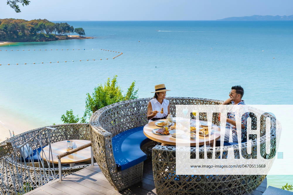 Couple having lunch at an restaurant looking out over the ocean of Pattaya Thailand, man and woman having dinner in restaurant by the ocean in Pattaya couple having lunch at a restaurant looking out over the ocean of Pattaya Thailand, man and woman having dinner in a restaurant by the ocean in Pattaya.