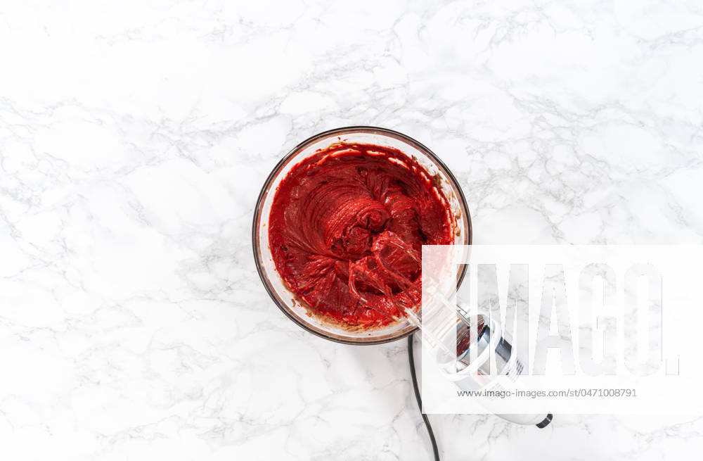 Red Velvet Cupcakes with White Chocolate Ganache Frosting Flat lay. Mixing wet ingredients in a large glass mixing bowl to bake red velvet cupcakes with white chocolate ganache frosting.