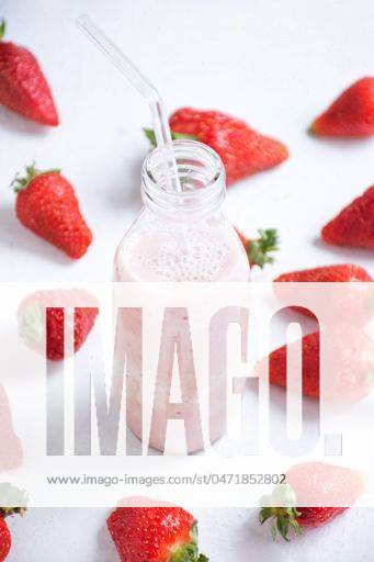 A glass bottle filled with strawberry-flavored milk surrounded by fresh strawberries 24436681 RECORD DATE NOT STATED