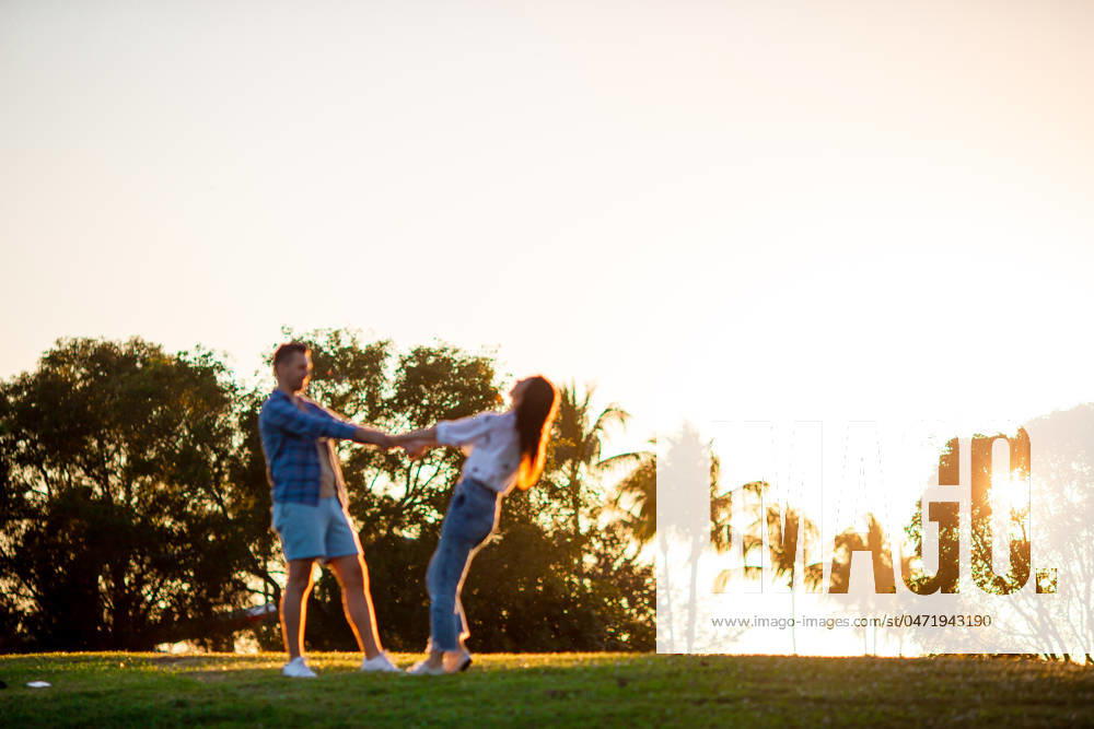Family of two in the park on summer day outdoors at sunset light Happy couple in the park on summer day outdoors. High quality photo