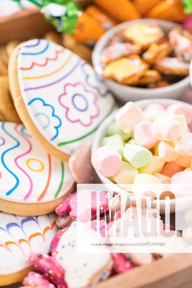 Easter charcuterie board Assembling charcuterie board with Easter candies, cookies, and marshmallows.
