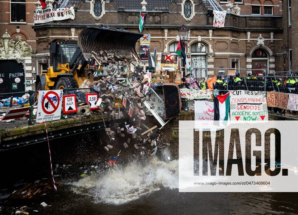 AMSTERDAM - A police shovel throws rubble from the barricades into a canal near the Binnengasthuis grounds of the University of Amsterdam (UvA). Entrances to the site were blocked from several sides with, among other things, pallets and bicycle racks. The demonstrators were protesting in solidarity with pro-Palestinian students who were removed by police during protests at the Roeterseiland campus. ANP RAMON VAN FLYMEN netherlands out - belgium out