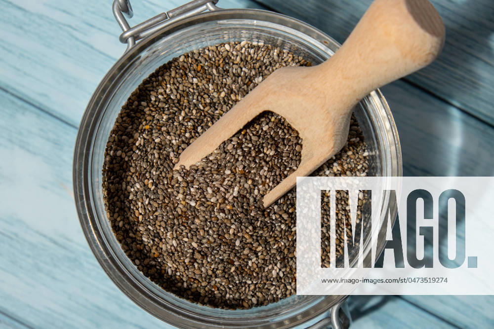 Chia seeds in glass jar. Healthy superfood rich in Omega 3 fatty acids. Dry healthy natural ingredient. Chia grains are falling Chia seeds in glass jar. Healthy superfood rich in Omega 3 fatty acids. Dry healthy natural ingredient. Chia grains are falling. Vegetarian food