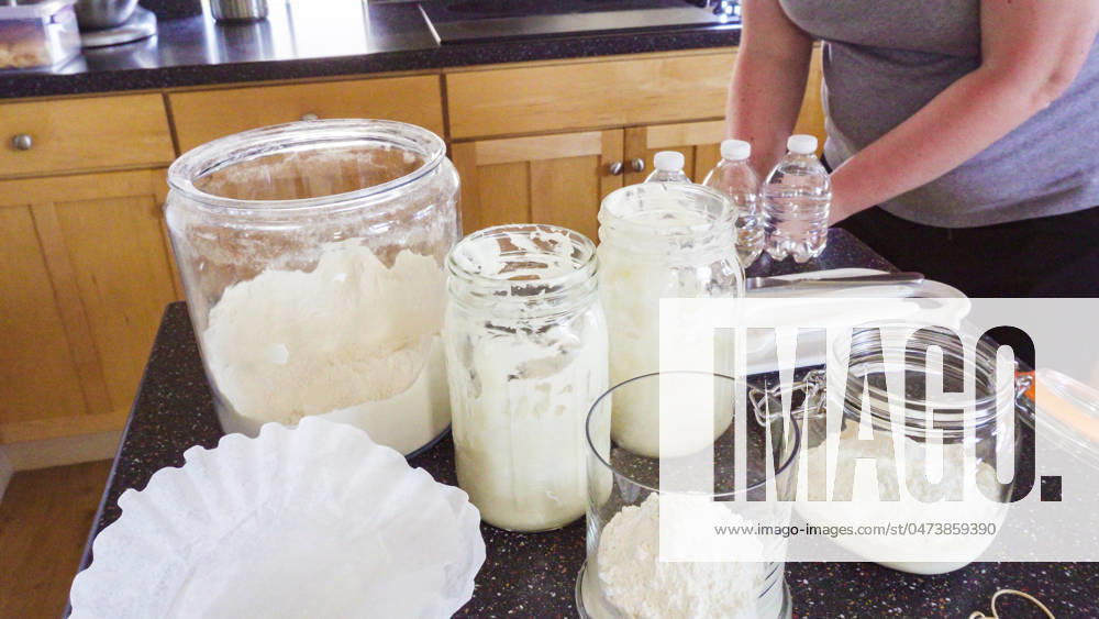 Sourdough starter Feeding sourdough starter with water and flour.