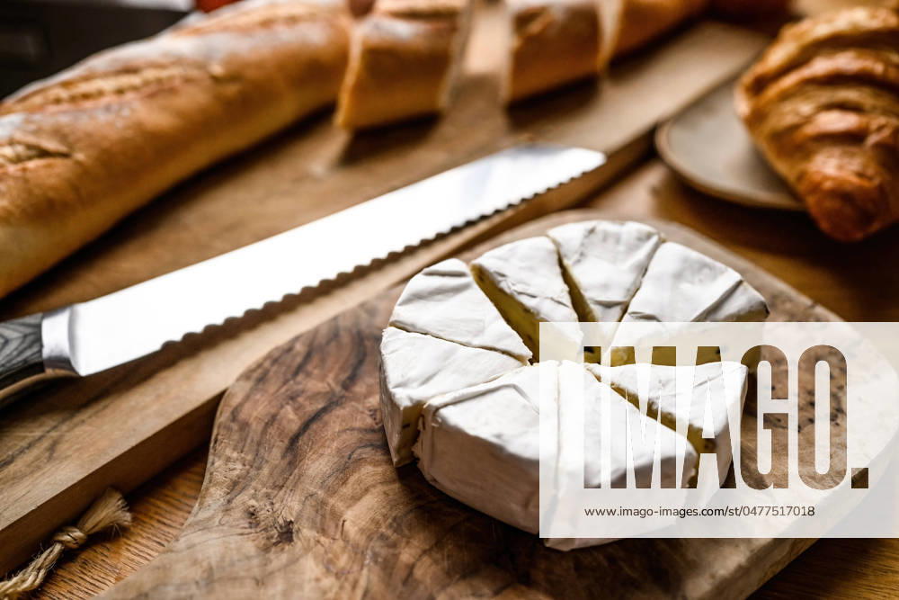 Delicious brie cheese with white mold Delicious brie cheese with white mold cutting for a breakfast on a kitchen table
