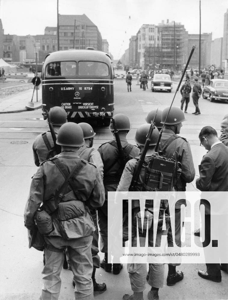 Bau der Berliner Mauer Soldaten der US-Army stehen mit geschulterten Gewehren und einem Emfangsgerät am Checkpoint Charlie, Berlin 1961. - Originale Bildbeschreibung: Gestern Zwischenfall an der Sektorengrenze Friedrichstr. Vopos wollten drei amerik. Busse nicht nach Ost-Berlin lassen - Drei amerikanische Busse trafen gestern gegen 14 Uhr 30 am Sektorenübergang Friedrichstr. ein. Da es die Amerikaner ablehnten sich von den Vopos kontrollieren zu lassen, wurde die Durchfahrt vorerst verweigert. Ein amerikanischer Oberst protestierte daraufhin bei den Sowjets, worauf die Busse unkontrolliert nach spannenden zwei Stunden endlich durchgelassen wurden. , Berlin