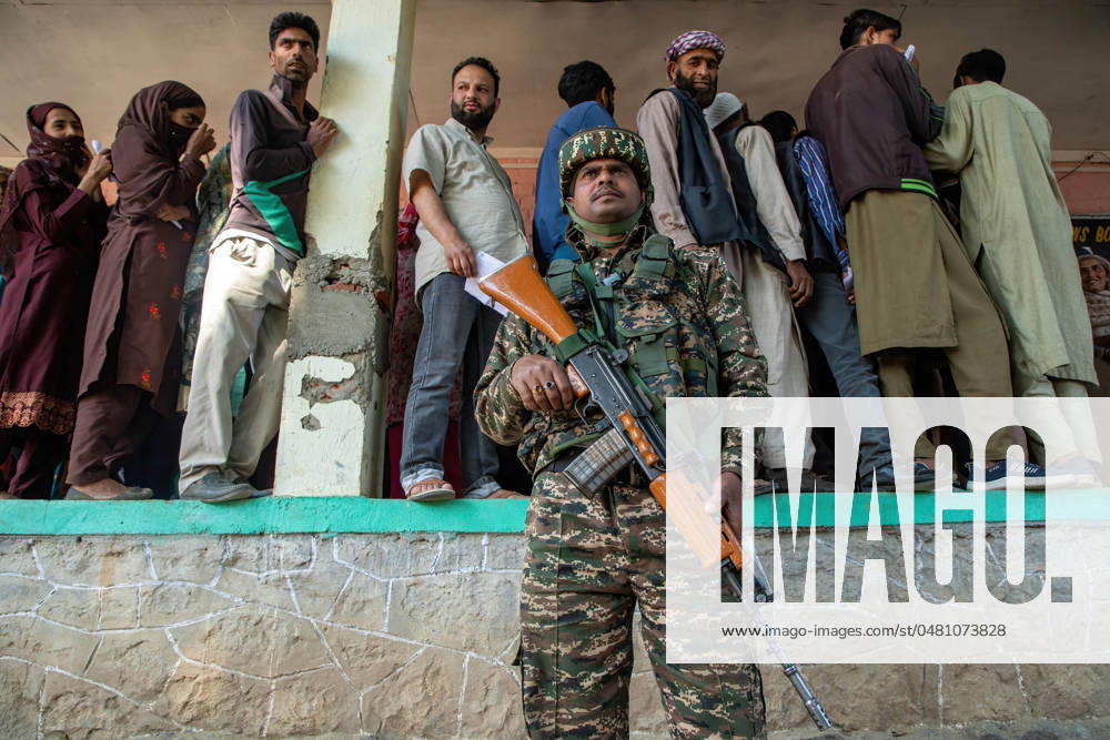 Indian paramilitary trooper stands on guard as Kashmiri voters wait in a queue to cast their votes outside a polling station during the sixth phase of the Lok Sabha, or lower house, of the Indian parliamentary elections in Pahalgam in south Kashmir, district of Anantnag-Rajouri parliamentary constituency. The 2024 Lok Sabha (lower house of Parliament) parliamentary elections mark the first major election in Jammu and Kashmir since New Delhi revoked Article 370, the region s special semi-autonomous status, and took direct control of it in 2019. Anantnag India - ZUMAs197 20240525_aaa_s197_021