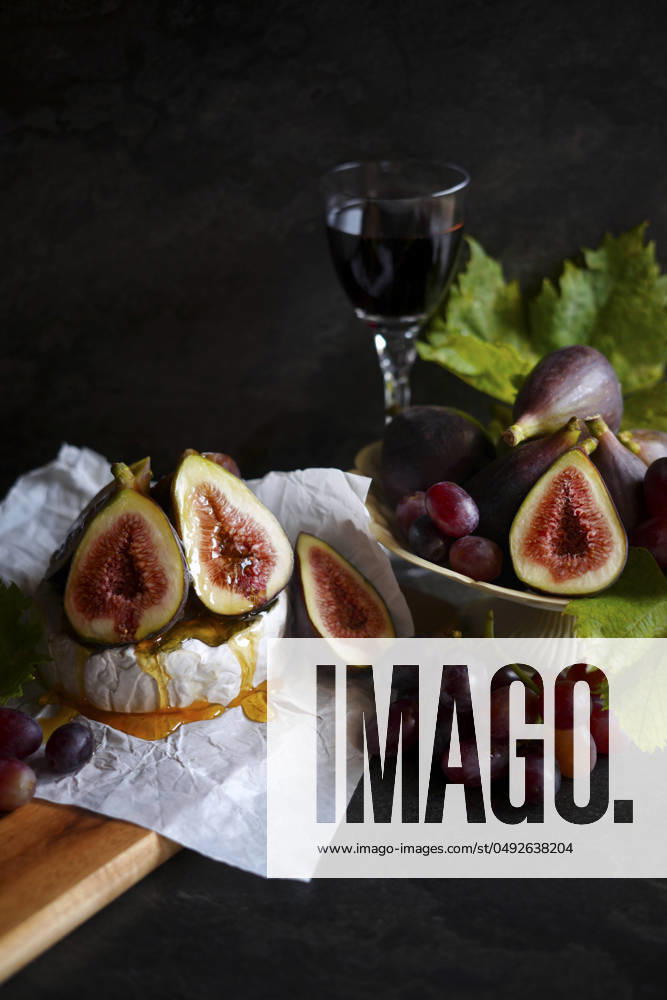 Brie cheese served with figs, honey and grapes. Brie cheese served with figs, honey and grapes.