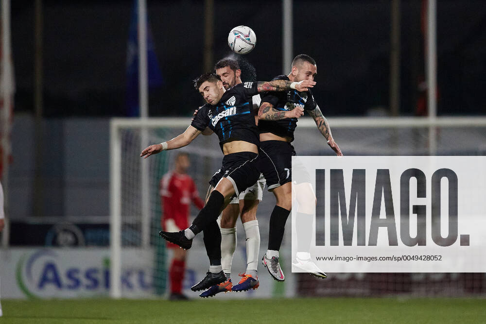 Valletta s Ryan Fenech (C) heads first ahead of the Tarxien Rainbows duo of Matthew Spiteri (L) and Darren Falzon (R) during the Malta BOV Premier League soccer match characterised by continuous rain at the Centenary Stadium, Ta Qali, Malta on 29 November 2020. Tarxien Rainbows v Valletta MPL_20_21