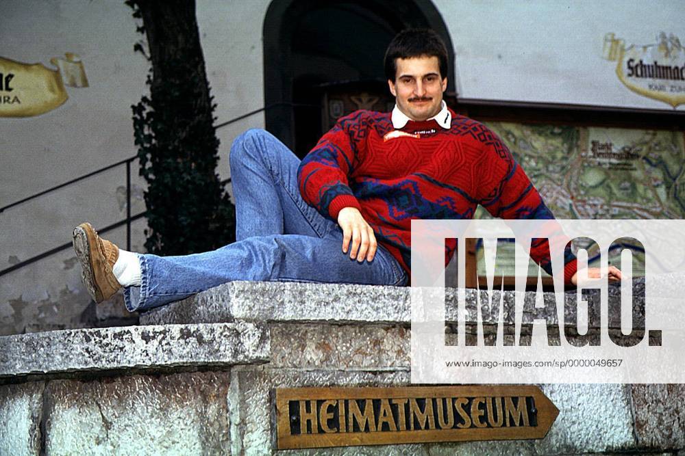 Georg Hackl auf einer Mauer sitzend, Wegweiser zum Heimatmuseum Rennrodeln Herren Rodeln, Rennschlitten, Rennschlittensport, Wintersport: Einsitzer Porträt Berchtesgaden