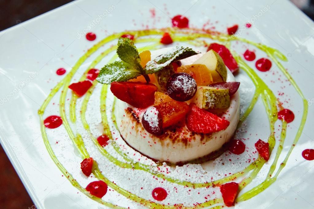 Photo of italian panna cotta dessert with strawberry sirup and mint leaf