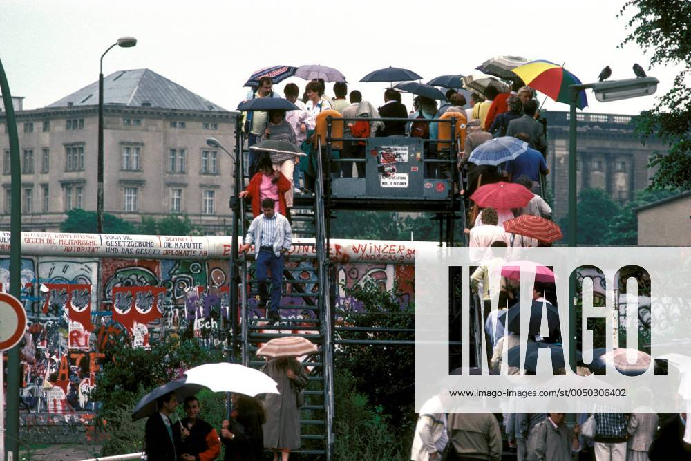 Westberliner schauen auf einer Aussichtsplattform über die Berliner Mauer anlässlich des Reaganbesuchs 1987