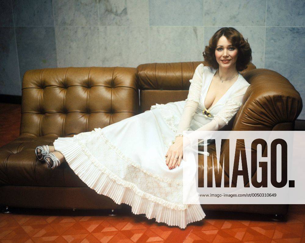 Sängerin Regina Thoss (GDR) im weißen Kleid auf der Couch