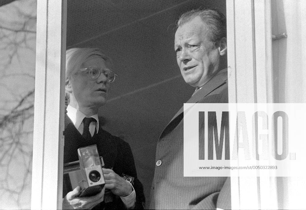 Bundeskanzler Willy Brandt (re., GER SPD) steht mit dem Künstler Andy Warhol (USA) am Fenster