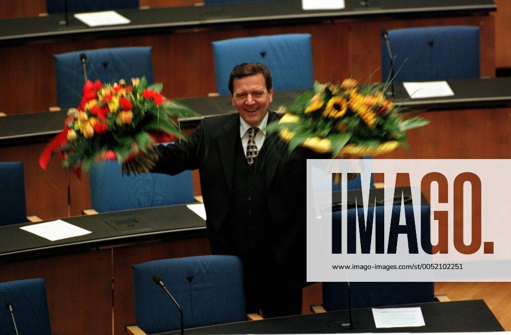Gerhard Schröder (GER SPD) nach seiner Wahl zum Deutschen Bundeskanzler mit Blumensträußen - im Bundestag in Bonn