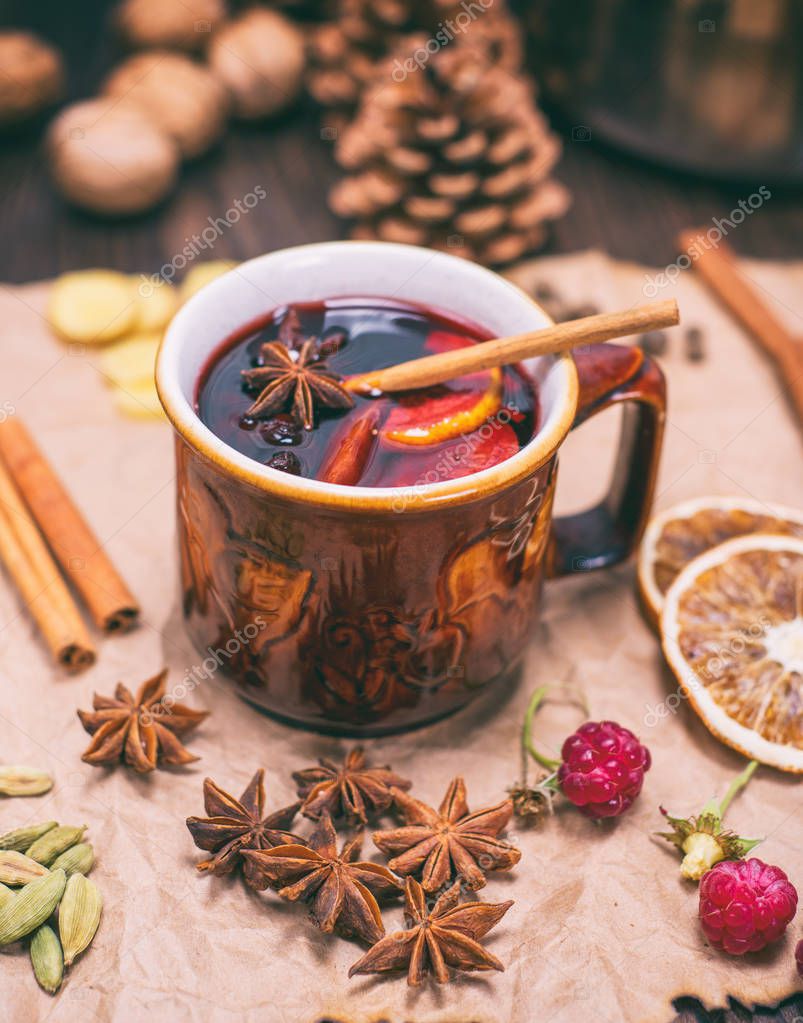 Drink mulled wine in brown ceramic mug on kraft paper, vintage toning