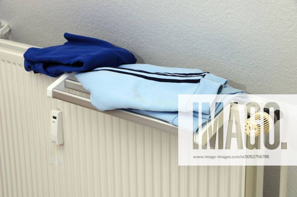 Kleidungsstücke liegen zum Trocknen auf einer Heizung