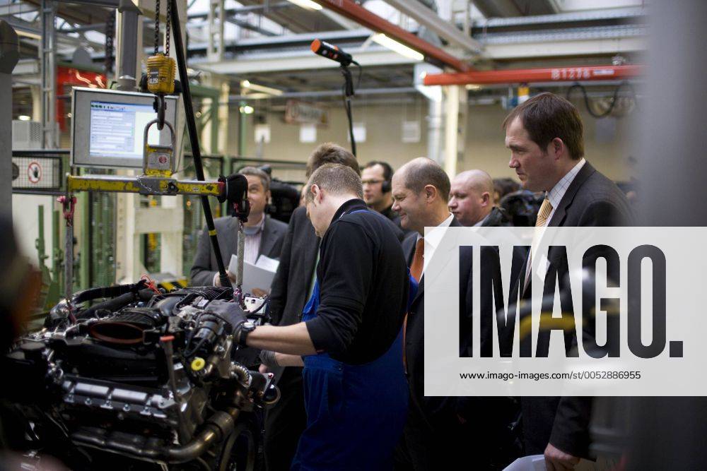 Arbeitsminister Olaf Scholz (Mitte, Deutschland SPD) schaut einem Mechaniker über die Schultern anlässlich der Besichtigung des Motorenwerks von Mercedes-Benz in Berlin