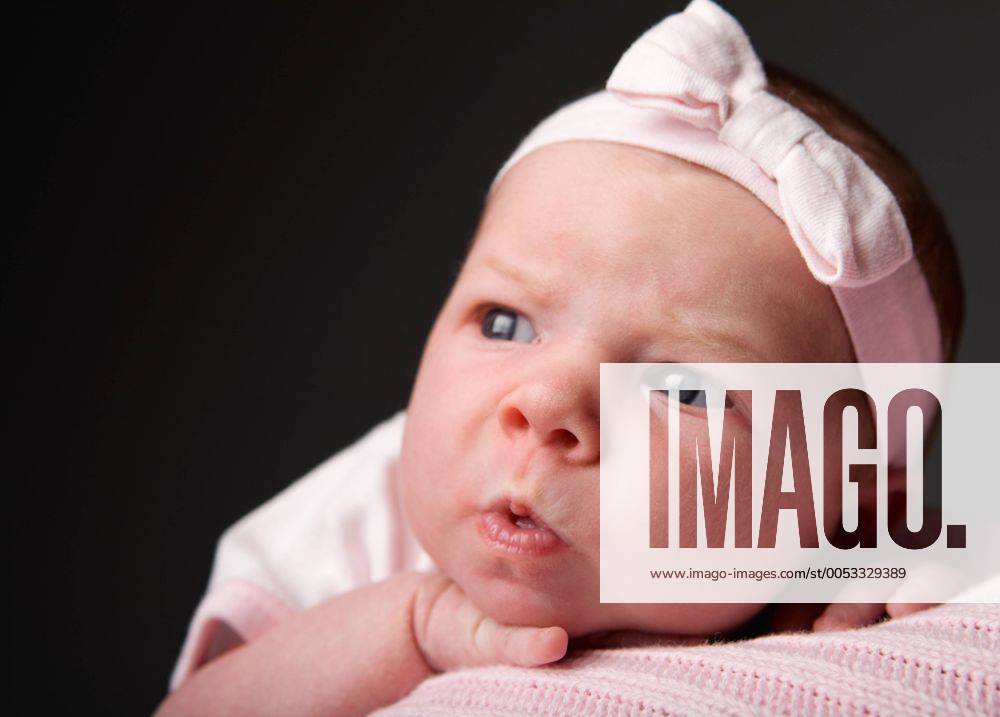 Baby Emotions. Studio portrait of 14 days old baby girl making funny face - McPSHI