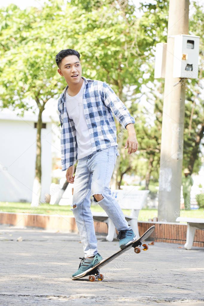 Young skater performing with skateboard in urban square, he jumping and doing tricks model released
