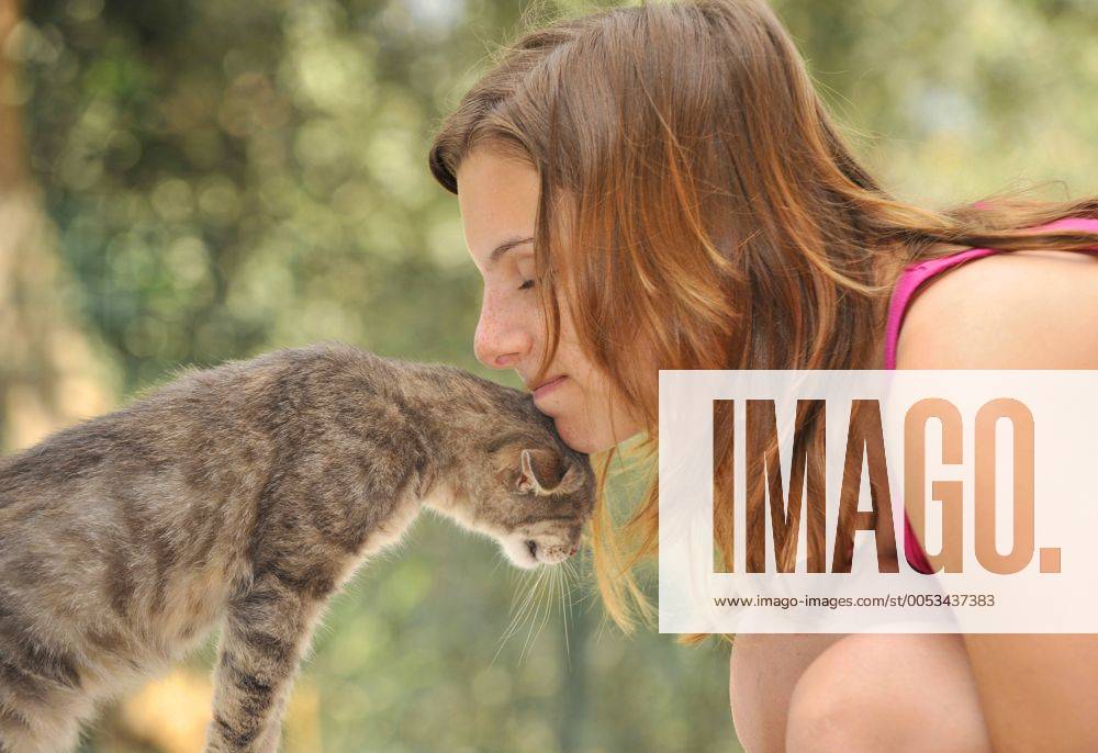 Junge Frau kuschelt mit ihrer Katze young woman cuddling with her cat BLWS177798