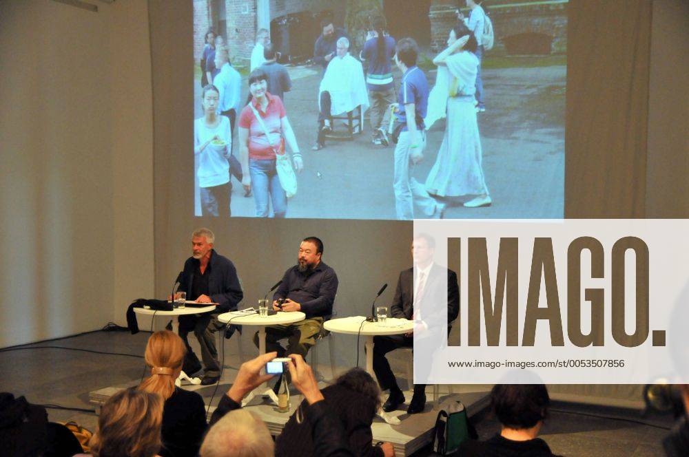 Pressekonferenz anlässlich der Installation, 100m lang x 10m hoch, aus 9000 verschiedenfarbigen Kinderrucksäcken an der Fassade des Hauses der Kunst München. Die chinesischen Schriftzeichen ergeben den Satz: Sieben Jahre lang lebte sie glücklich in dieser Welt, und erinnert an die Tausende durch das Erbeben am 12 Mai 2008 verschütteten Schulkinder. Gesprächspartner, in der Mitte der Künstler AI WEIWEI, links der Direktor des Hauses der Kunst München CHRIS DERCON. Pressekonferenz zur Installation REMEMBERING