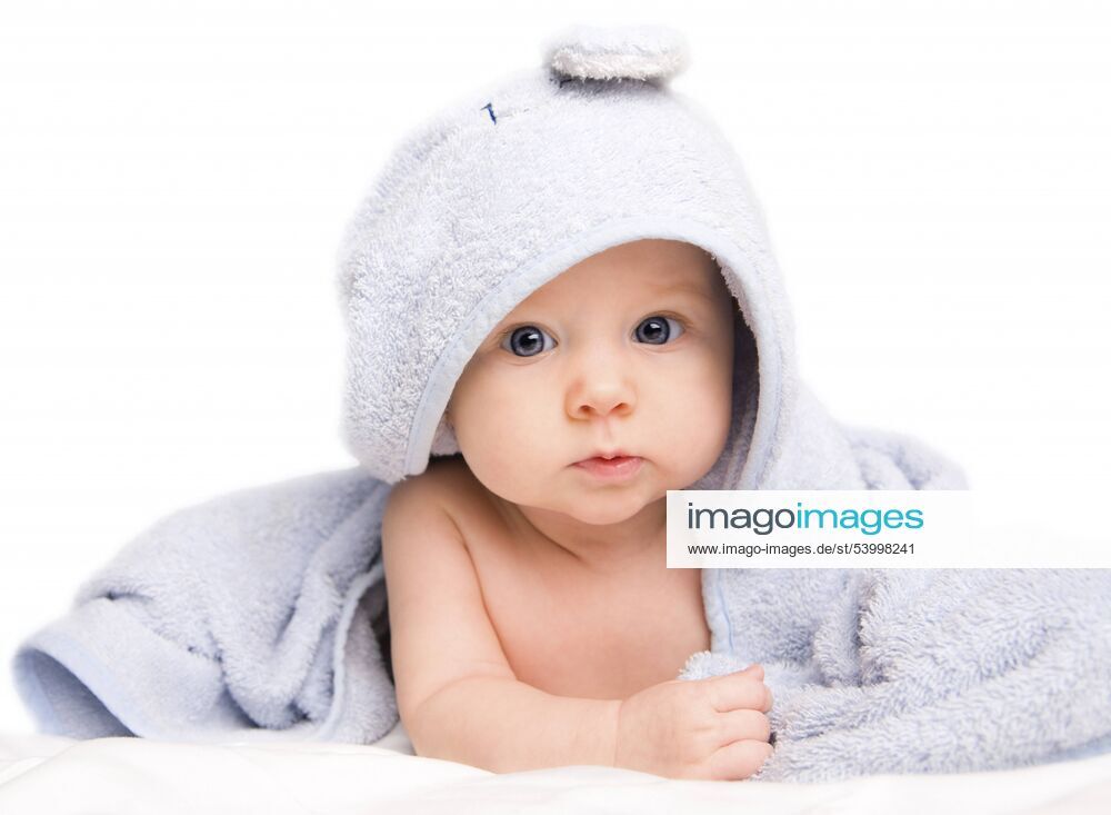 Kleines niedliches Baby liegt in einem Badehandtuch eingewickelt auf dem Boden Cute baby girl with towel after bath BLWS233199