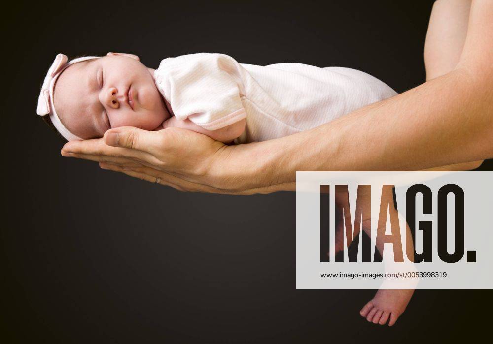 Schuetzende Haende. Vater haelt ein 14 Tage altes Baby in seinen Armen Supporting Hands. Father holding his 14 days old baby girl on his arms BLWS238338