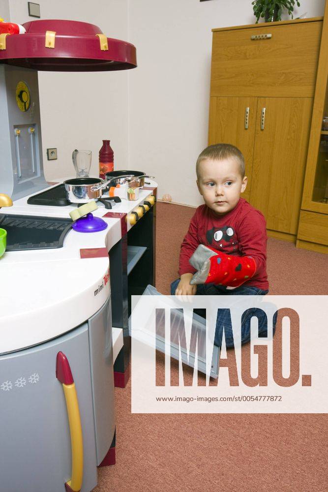 Junge, 2 Jahre, mit Spielzeugküche ibxgig01792115