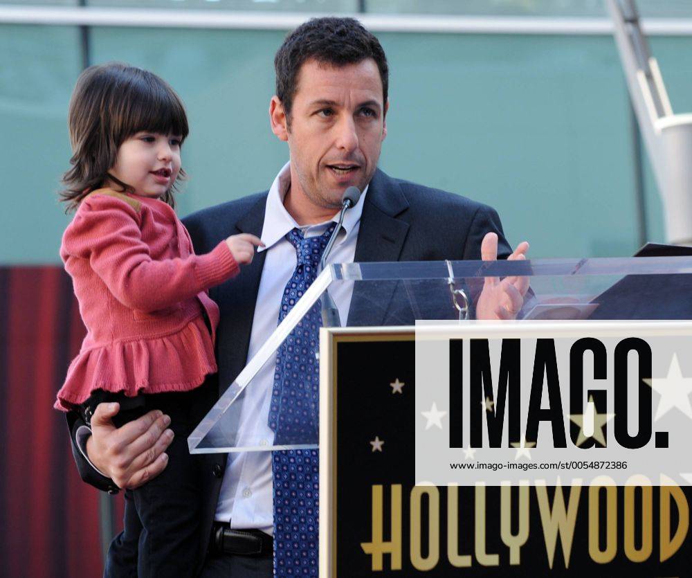 Actor Adam Sandler holds his daughter Sunny as he makes comments during an unveiling ceremony honoring him with the 2,431st star on the Hollywood Walk of Fame in Los Angeles on February 1, 2011. LAP2011020114