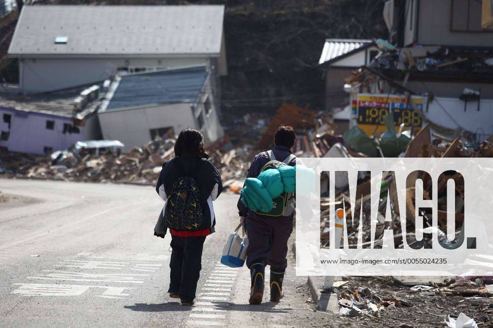 (110314) -- OFUNATO, March 14, 2011 (Xinhua) -- Two residents walk along the road near the ruins in Ofunato city of Japan s northeastern Iwate Prefecture, March 14, 2011. (Xinhua Cheong Kam Ka) (zyw) JAPAN-OFUNATO-QUAKE