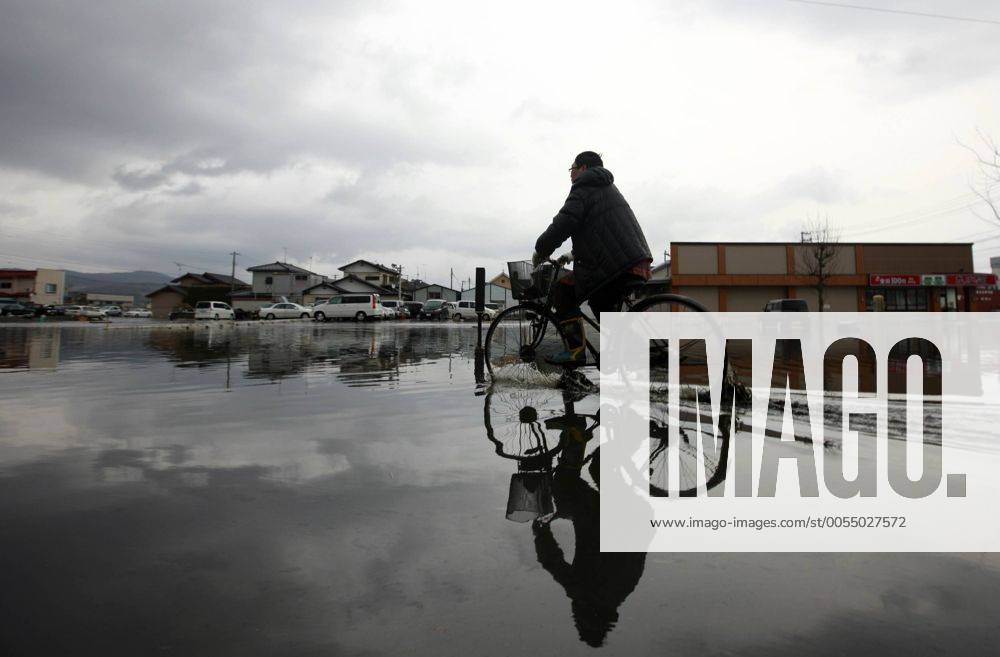 (110315) -- ISHINOMAKI, March 15, 2011 (Xinhua) -- A man rides through water in the quake-hit area of Ishinomaki city, Miyagi Prefecture, Japan, March 15, 2011. (Xinhua Ren Zhenglai) (zcc) JAPAN-QUAKE